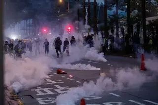 2019年8月11日，在香港灣仔的街道上，有人在示威，警察發射催淚彈。