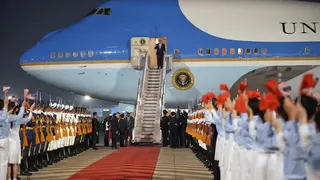 美國總統川普（中）搭乘空軍一號專機抵達北京，國家副主席韓正親自迎接。（美聯社）