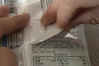 消費者撕下包裝外的中文配方表。(取材自河南廣播電視台都市報導)
