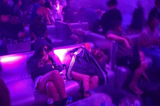 People sleep on a sofa in a nightclub in Yangon while others dance to loud music on May 16 Photo:  AFP