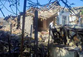 A resident stands at a site where a house was heavily damaged by a Russian drone strike, amid Russia's attack on Ukraine, in Mykolaiv, Ukraine June 12, 2026.