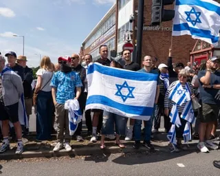 People stock in street holding Israeli flags