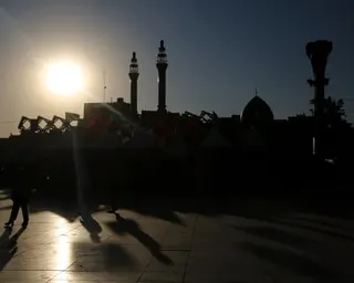Minarets and domes are silhouetted against the rising sun in a square in Tehran.