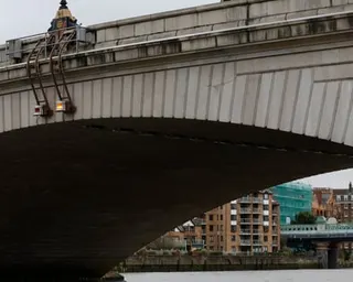 Closeup view of a stone arch of Putney Bridge over the River Thames.