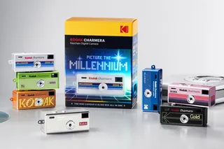 The collection of Kodak Charmera Millennium Edition cameras next to their packaging and retro gadgets.
