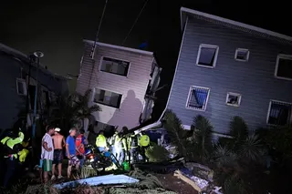 Residents and emergency workers stand near damaged buildings following an earthquake in Catia La Mar, some 30kms north-west of Caracas, early on June 25, 2026.
