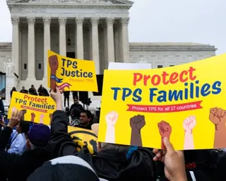 people hold signs that read 'TPS justice' and 'protect TPS families'