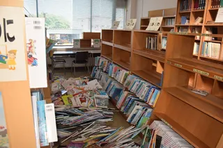 青森县八户市一家图书馆在地震后，书籍散落一地。（法新社）