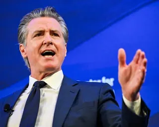 A middle-aged man in a suit gestures while speaking