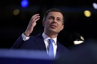 pete buttigieg, a man in suit speaking on stage with hand gestured