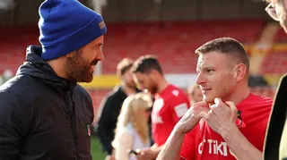 Ryan Reynolds (left) chats with Paul Mullin on the pitch following a game