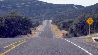 A scenic view of Ranch Road 337 winding through the Texas Hill Country.