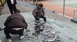 涉事學校老師拿鐵槌將沒收來的學生手機當眾砸毀。（視頻截圖）