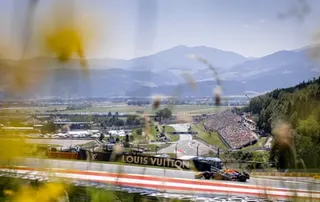 Max Verstappen during free practice at the Red Bull Ring with hills in the background.
