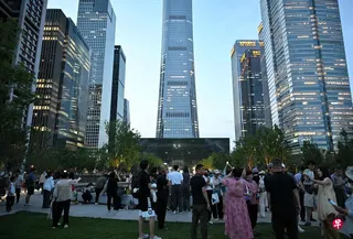 北京大批民众星期五（6月26日）傍晚在小飞机撞击事故发生后聚集在中信大厦（也名“中国尊”，中）附近。 （法新社）