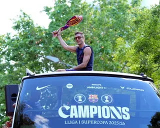 Robert Lewandowski sits on top of a bus roof waving a Barcelona scarf