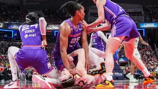 Phoenix Mercury forward Alyssa Thomas scrambling to get up over Indiana Fever guard Caitlin Clark during a basketball game
