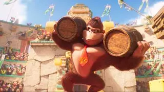 Donkey Kong carries two big barrels on his shoulders in a stadium full of apes in The Super Mario Bros. Movie
