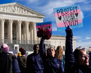 people hold signs that read 'protect trans youth'