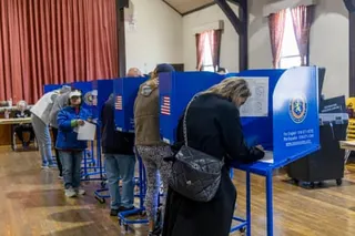 people fill out ballots at voting booths