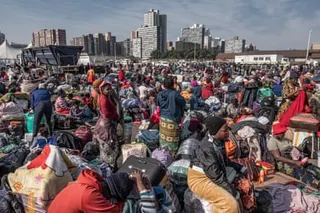 Malawian migrants in Durban wait to board buses at a makeshift displacement camp.