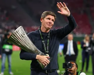 Oliver Glasner waves to the Crystal Palace fans while holding the Conference League trophy
