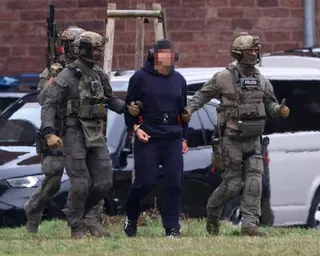 Serhiy Kuznietsov being led handcuffed by armed German police.