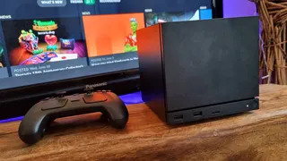 A Steam Machine and Steam Controller, side-by-side in front of a TV