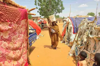 A Sudanese woman carrying a plastic canister in al-Rahmaniyah camp for displaced people near El-Obeid in Kordofan