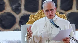 Pope Leo speaks at a podium.