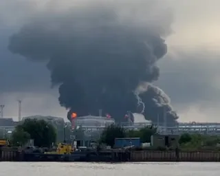 Black smoke rises from fires in an industrial waterside facility