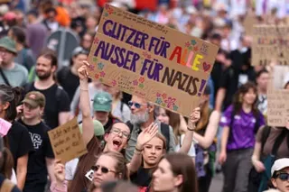 Protesters hold a sign that reads: "Glitter for everyone, except for Nazis"