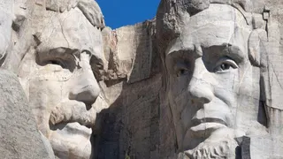 The faces of Teddy Roosevelt and Abraham Lincoln on Mount Rushmore