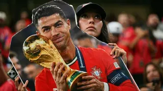 A Portugal fan holds a cardboard cutout of Cristiano Ronaldo with the World Cup trophy during the World Cup
