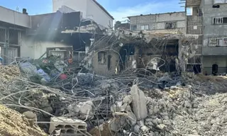 Rubble in the foreground with a destroyed part of the hospital behind