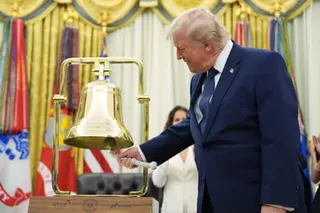 a man in a suit rings a bell