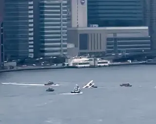 an image of a plane in water with boats surrounding it