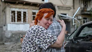 An upset woman hugs another person