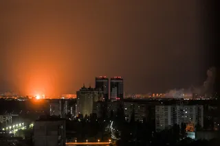 乌克兰首都基辅7月6日遭俄罗斯导弹袭击，黑暗中远处升起橙色爆炸火光。（法新社）