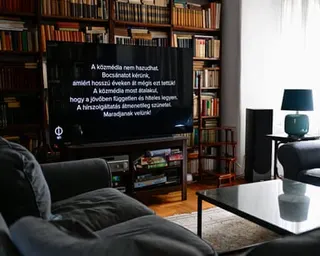 A TV in a living room with a message in Hungarian on the screen