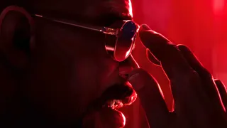 Blade, affixing sunglasses to his face, in red