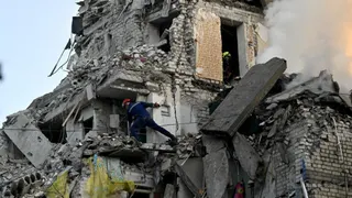 Des secouristes ukrainiens à la recherche de survivants dans les décombres d'un immeuble frappé par une attaque russe, le 2 juillet 2026, à Kiev.