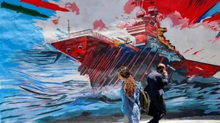 民众在伊朗首都德黑兰，走过一幅描绘军舰遭导弹袭击的反美壁画。（图取自法新社）