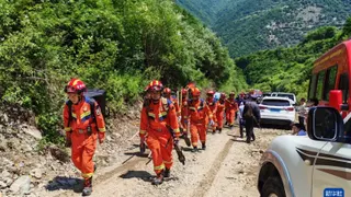 救援人员周二步行前往中国甘肃省陇南市宕昌县南河镇任藏村的山体滑坡现场，展开救援工作。（图取自新华社）