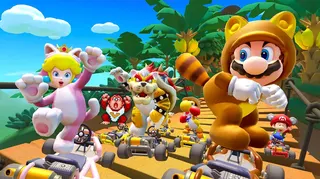 A screenshot of Mario Kart Tour, featuring Tanooki Mario, Cat Peach, Meowser, Kangaroo Yoshi, Baby Mario and 16-bit Donkey Kong racing over a wooden bridge