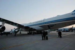 People walk on tarmac near Air Force One with "UNITED STATES OF AMERICA" on its side
