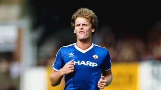 Footballer Gordon McQueen in action for Manchester United while wearing the club's blue kit