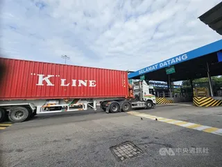 貨櫃車載運貨櫃進出馬來西亞巴生港碼頭，港區日夜裝卸、轉運全球貨物，支撐馬來西亞對外貿易與區域物流發展。中央社記者黃自強巴生攝　115年7月9日