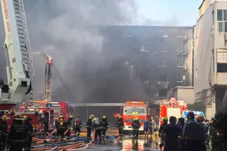 中国官方媒体发布的照片显示，消防员在周四发生于中国东南部城市晋江的一家鞋厂火灾现场展开救援。