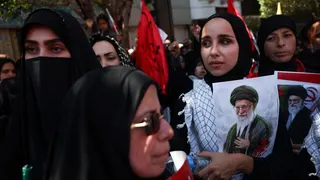 Mourners hold photos of Iran's late Supreme Leader Ayatollah Ali Khamenei ahead of his burial in Mashhad, north-eastern Iran (9 July 2026)
